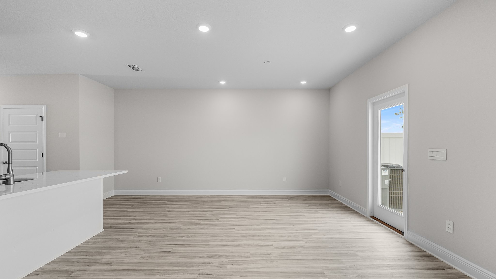 Open living room with EVP flooring and back door.