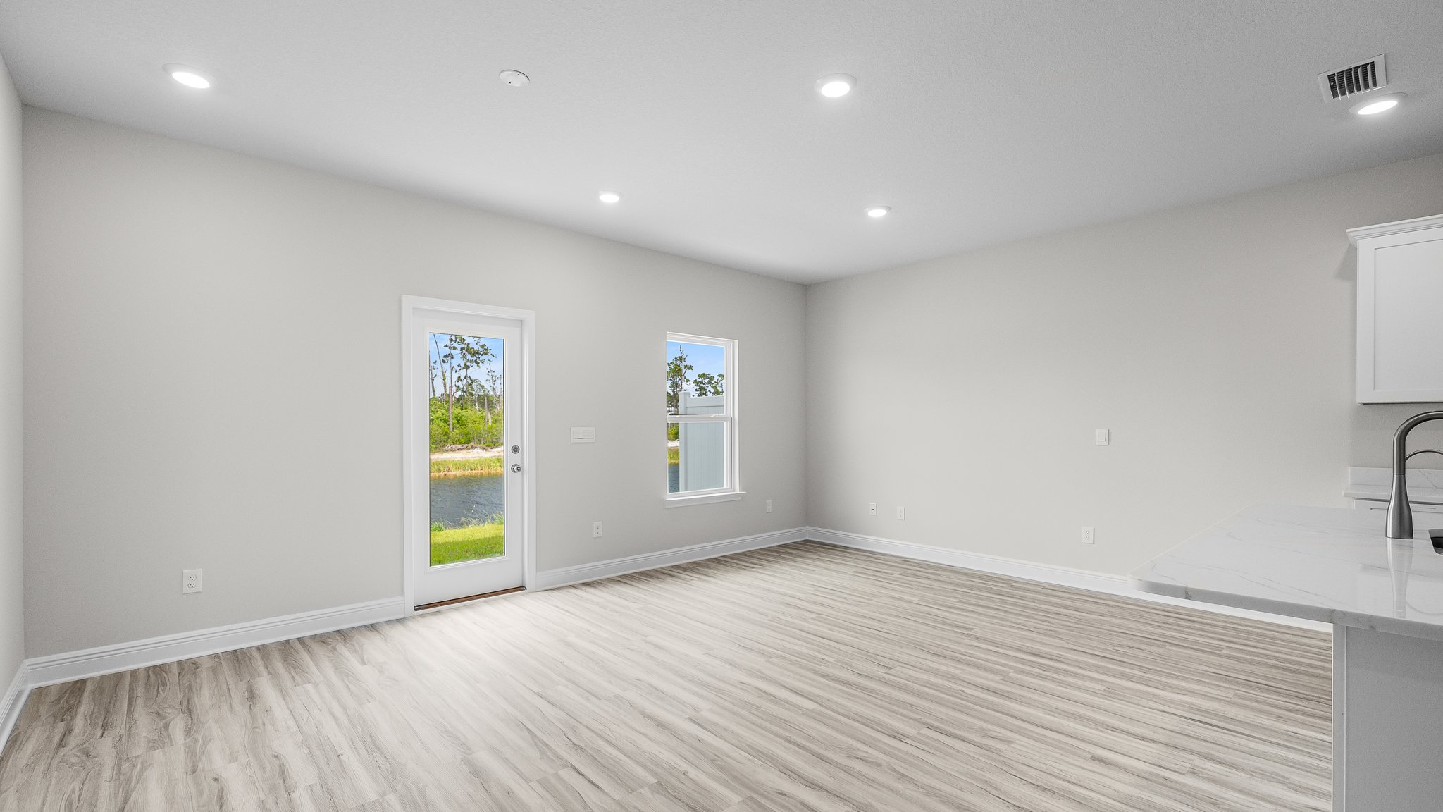 Open living room with EVP flooring and back door.