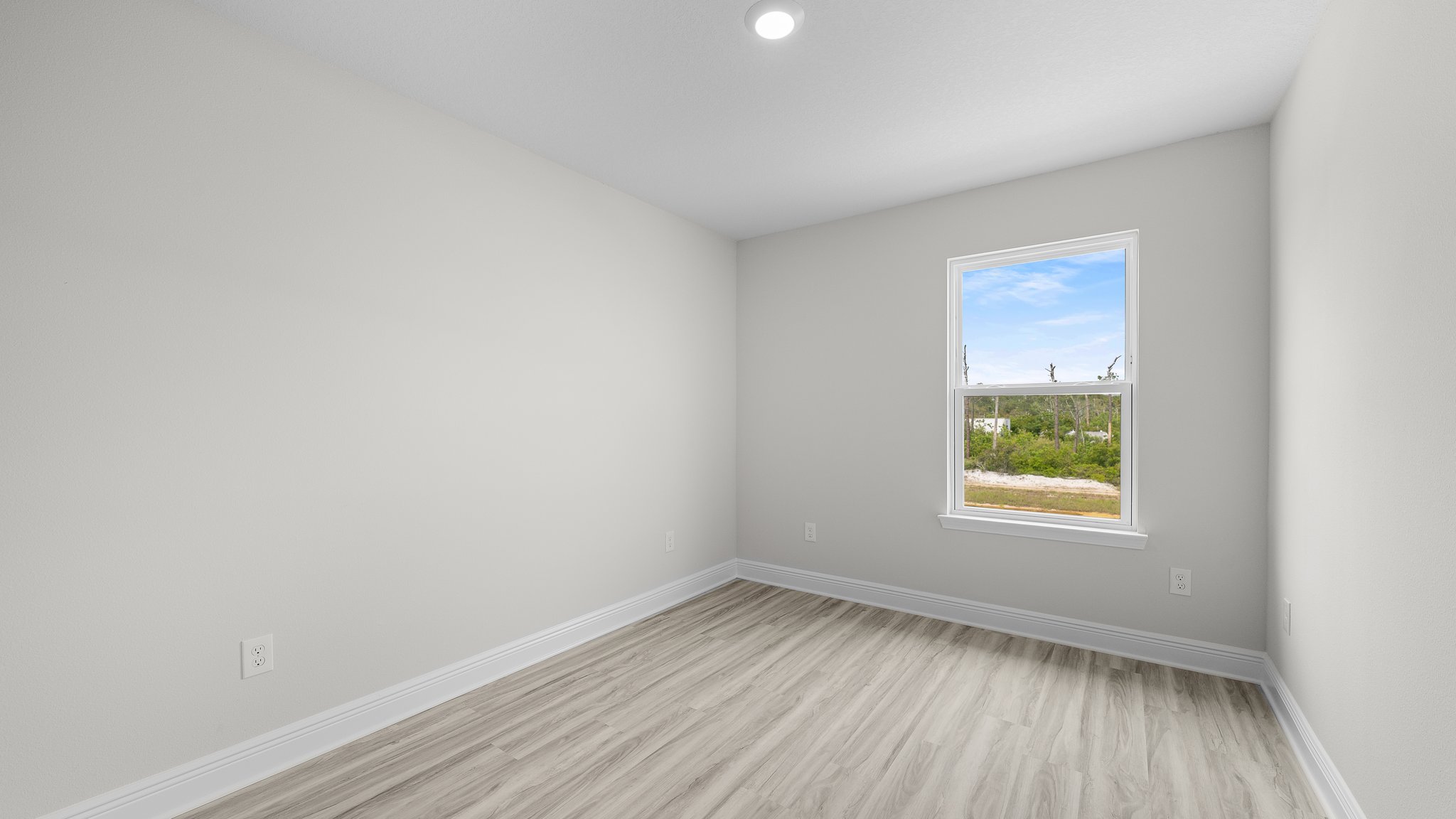 Bedroom with EVP flooring and window.