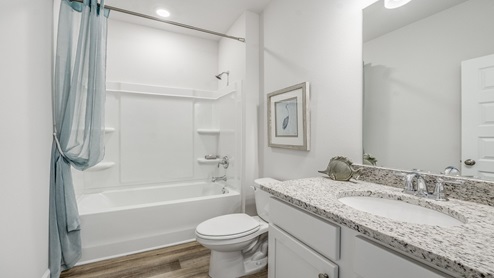 Hodges Bayou Plantation model home bathroom with granite countertops and single vanity and shower.