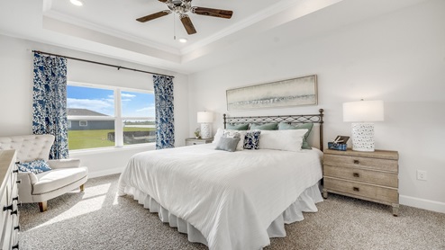 Hodges Bayou Plantation model home master bedroom with carpet floors and tray ceilings.