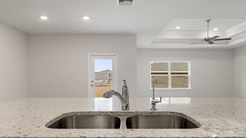 Kitchen peninsula with granite countertops and undermount sink.