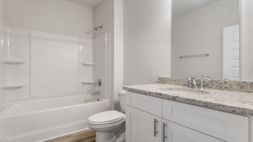 Bathroom with granite countertops and single vanity and shower.