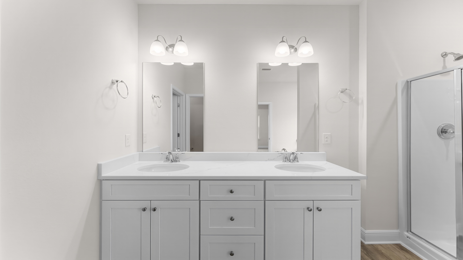 Primary bathroom with double vanity quartz countertops with white cabinets.