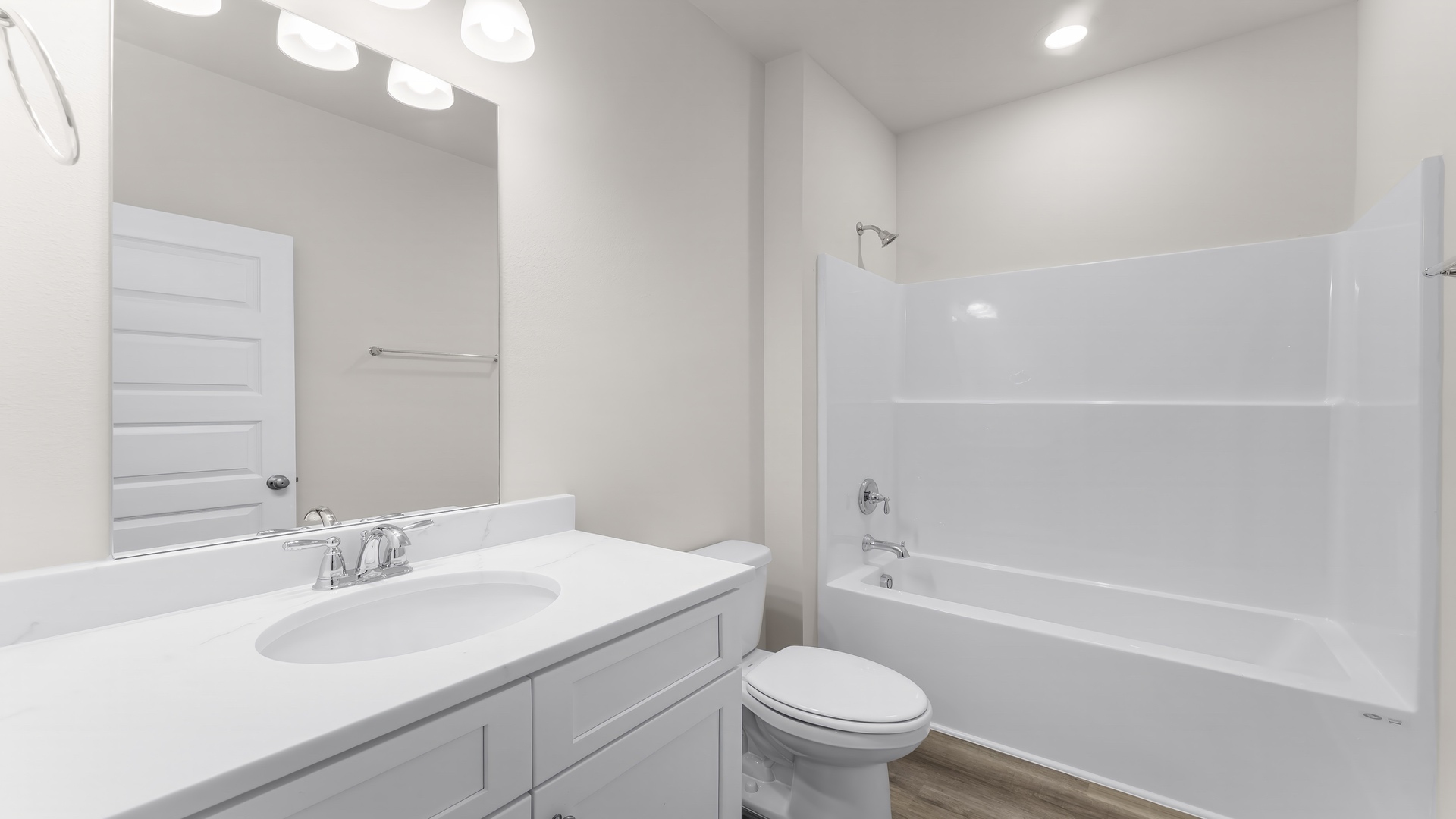 Bathroom with quartz countertops and white cabinets and single vanity and shower.