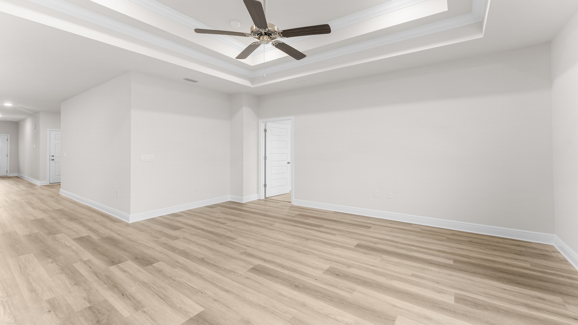 Living room with tray ceilings and ceiling fan and EVP flooring.