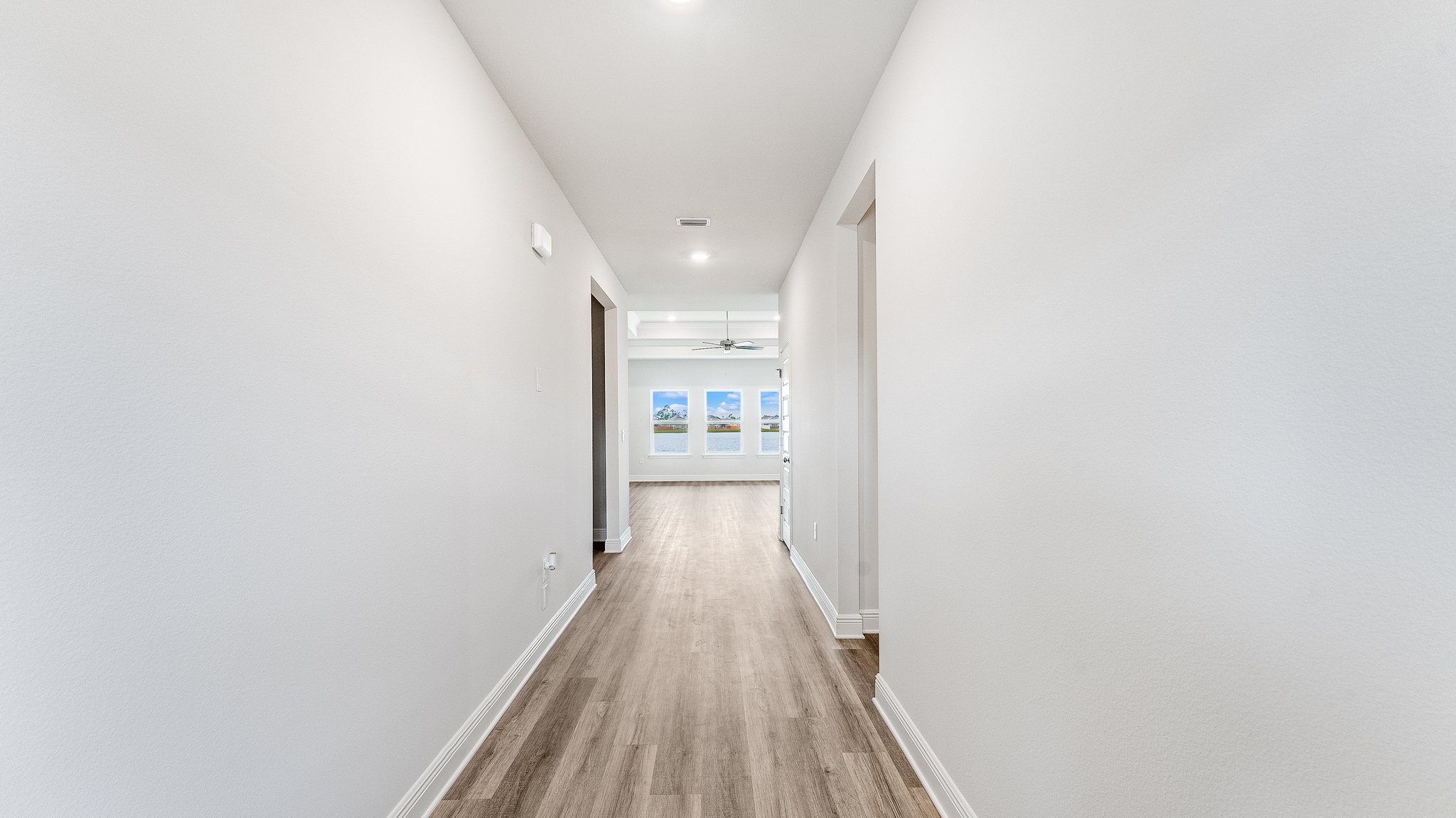 Front entrance with hallway with EVP flooring next to bedrooms and bathroom and laundry room.
