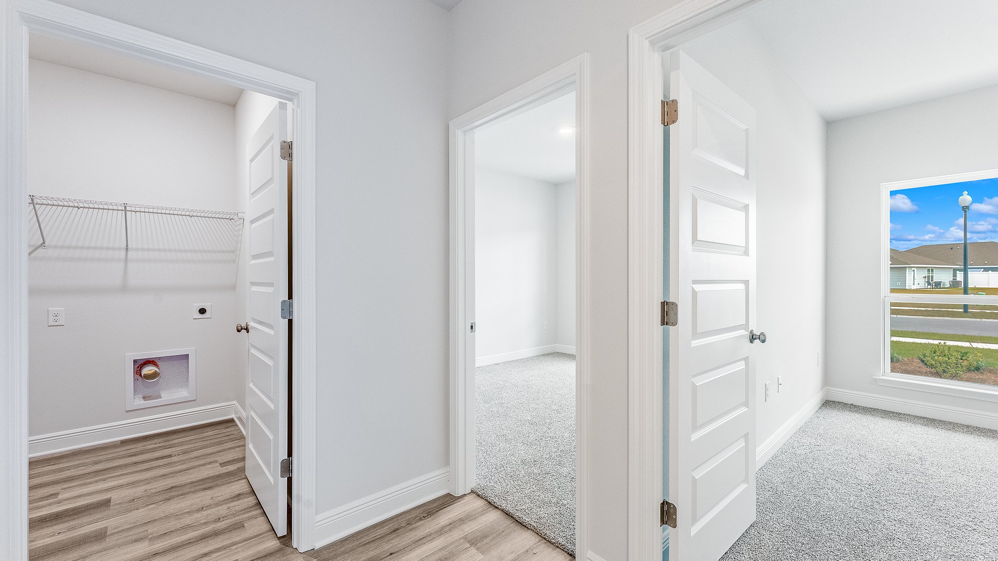 Hallway with EVP flooring next to bedrooms and bathroom and laundry room.