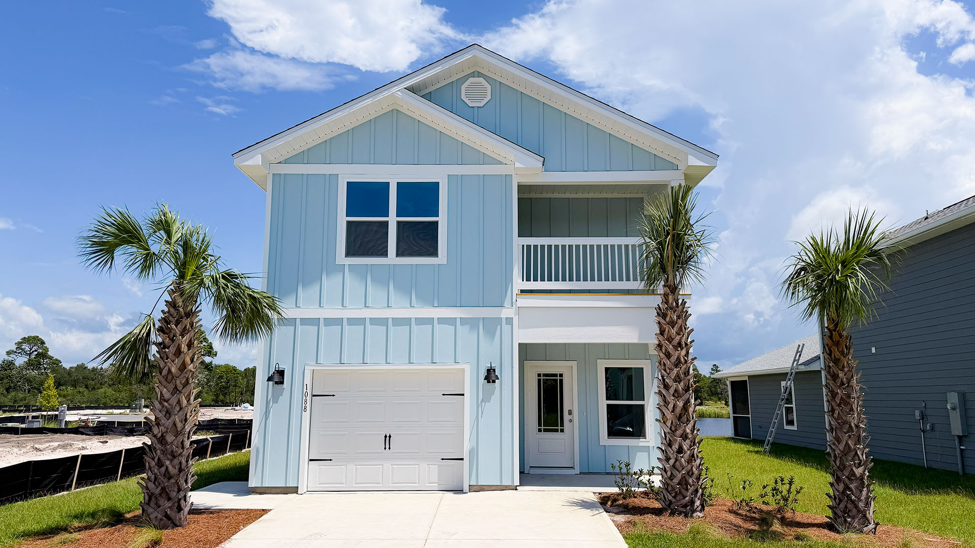 Monroe floor plan at WindMark Beach with Hardie siding and covered front porch and balcony and 1 car garage.