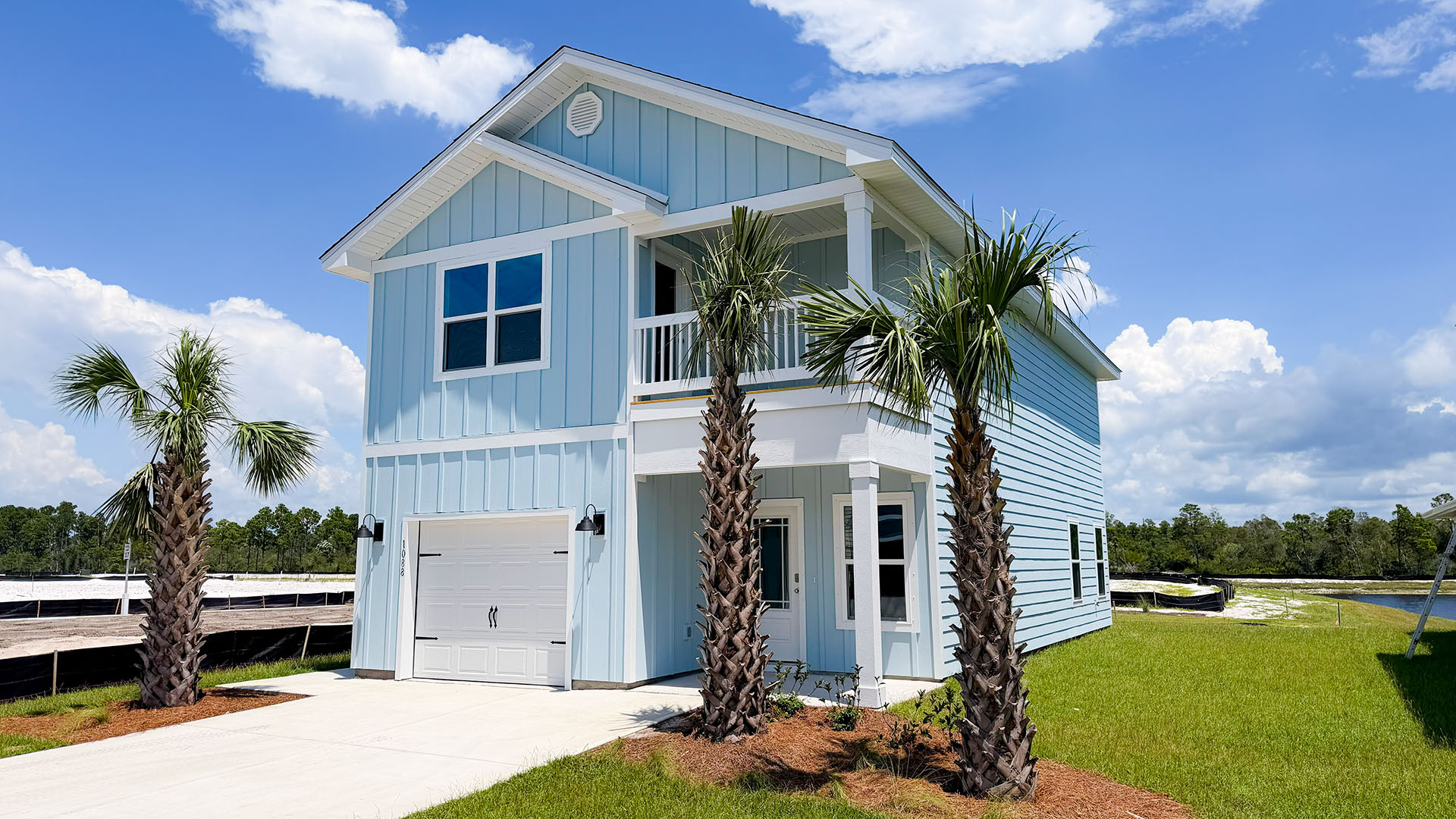 Monroe floor plan at WindMark Beach with Hardie siding and covered front porch and balcony and 1 car garage.