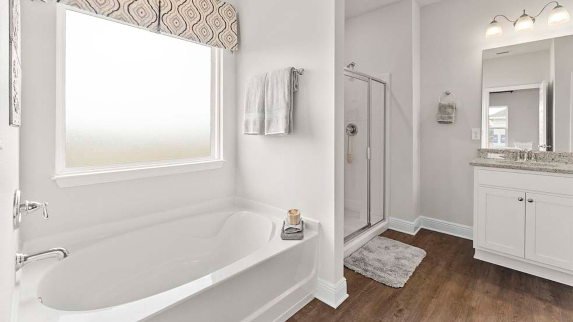Primary bathroom with shower with glass doors and tub.