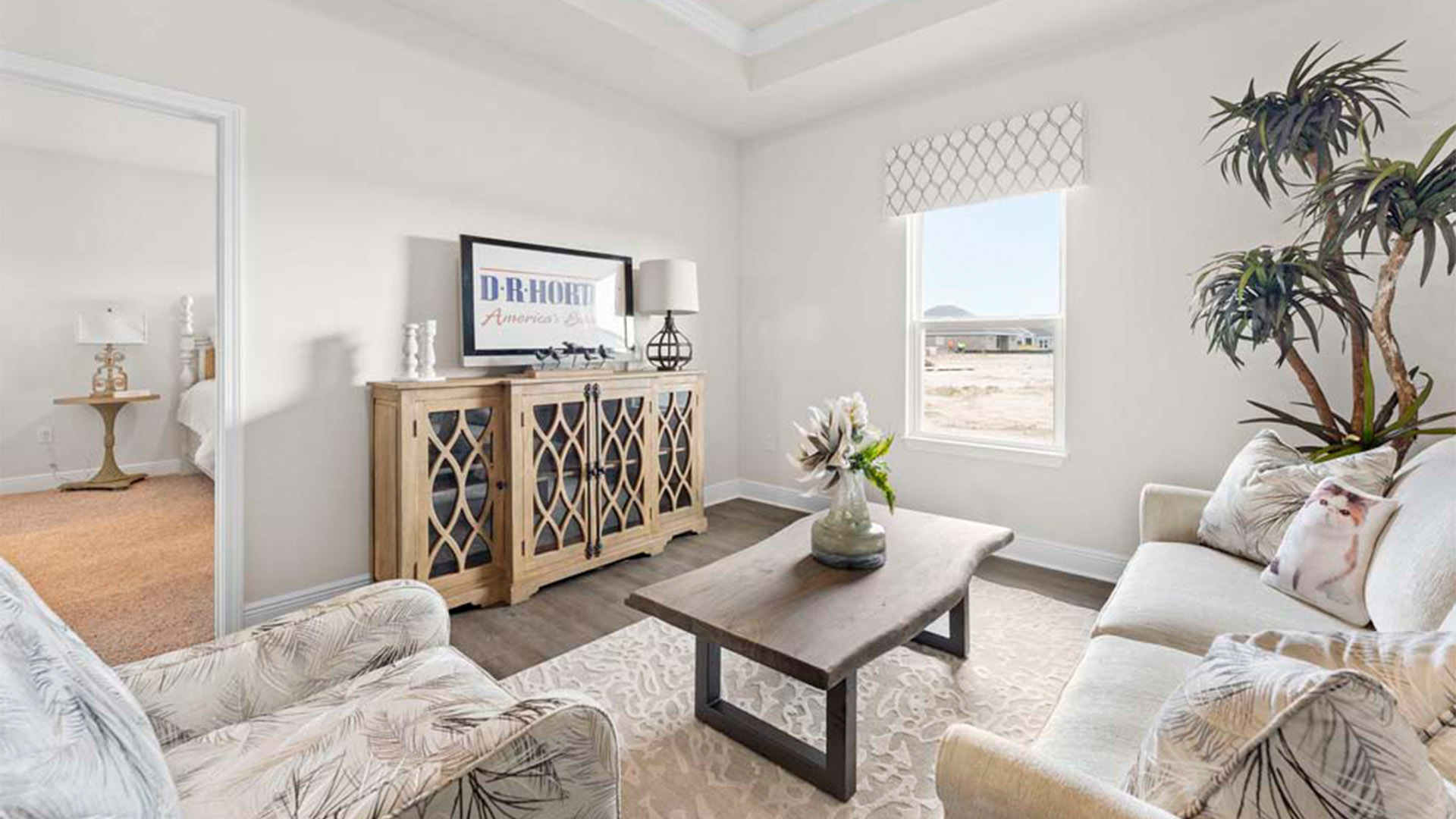 Bonus room with tray ceilings with EVP flooring and window next to bedroom.