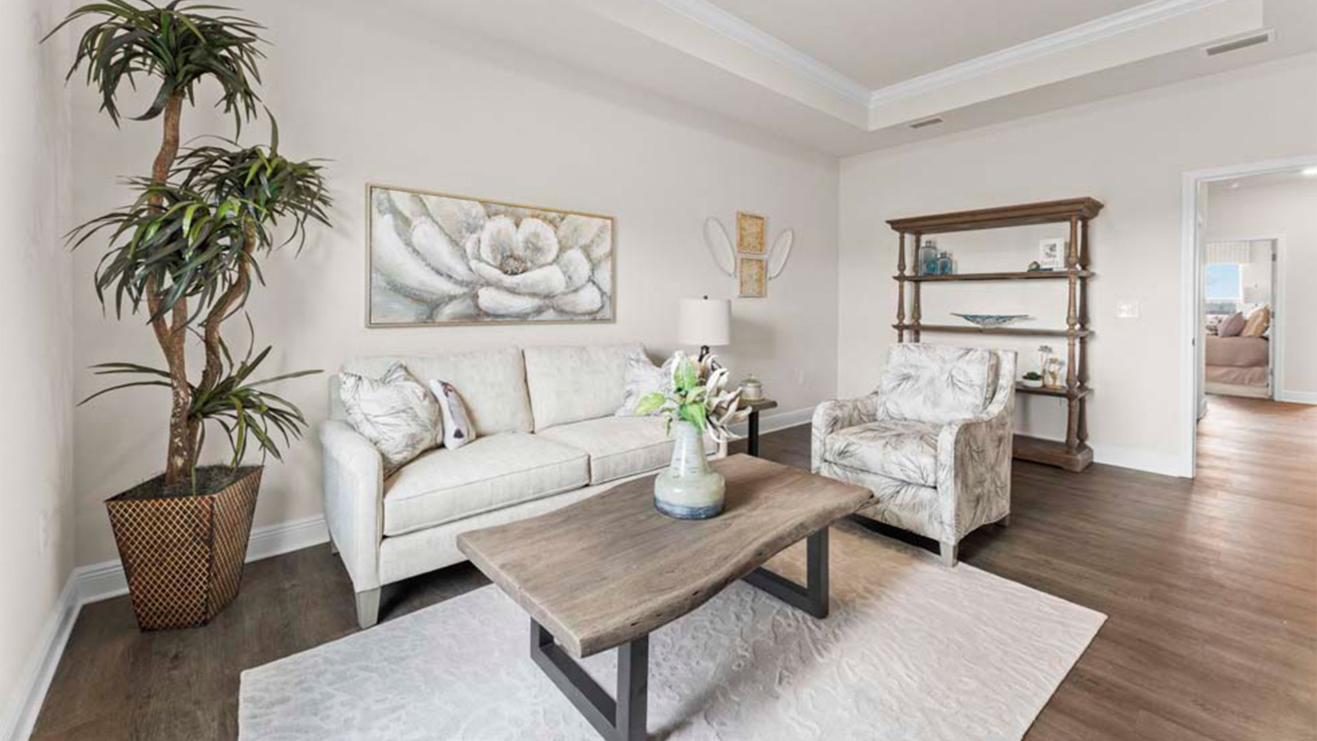 Bonus room with tray ceilings with EVP flooring next to bedroom.
