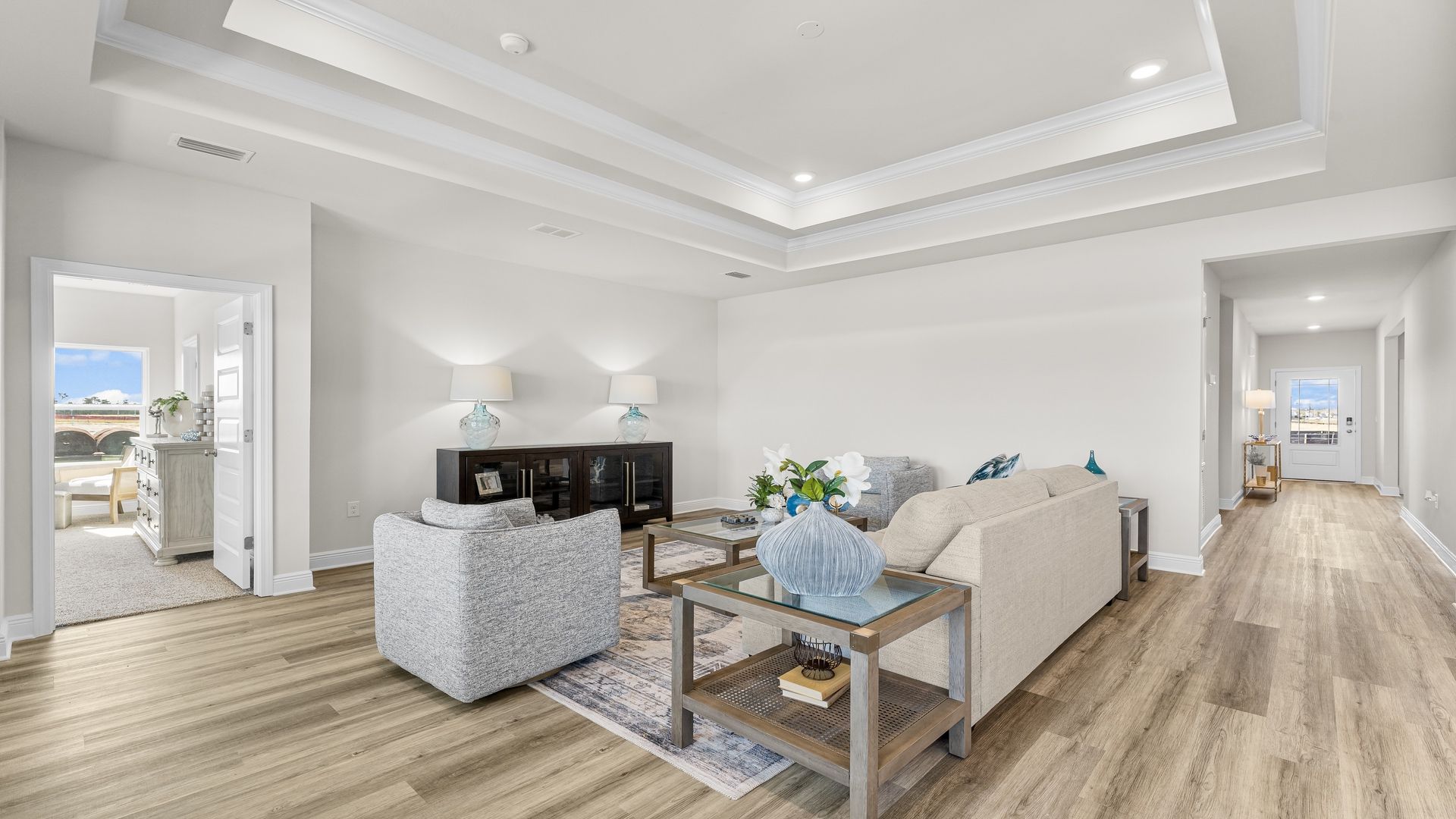 Open living room with EVP flooring and tray ceilings.
