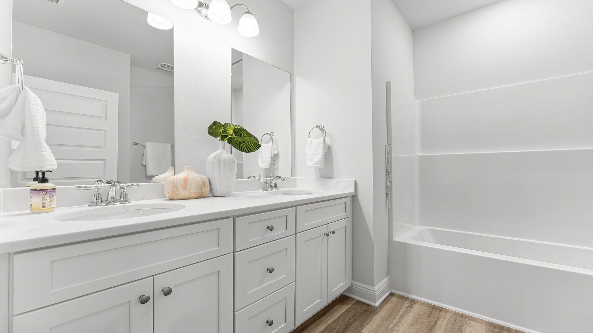 Bathroom white cabinets and double vanity with quartz countertops.