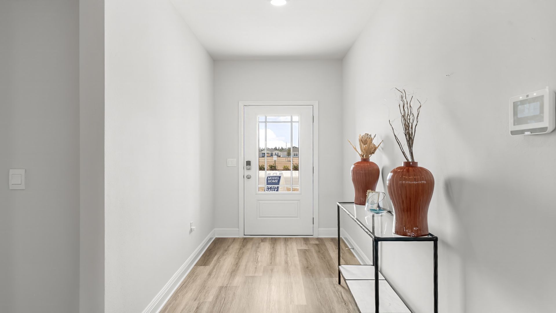 Front entrance with hallway with EVP flooring next to bedrooms and bathroom and laundry room.