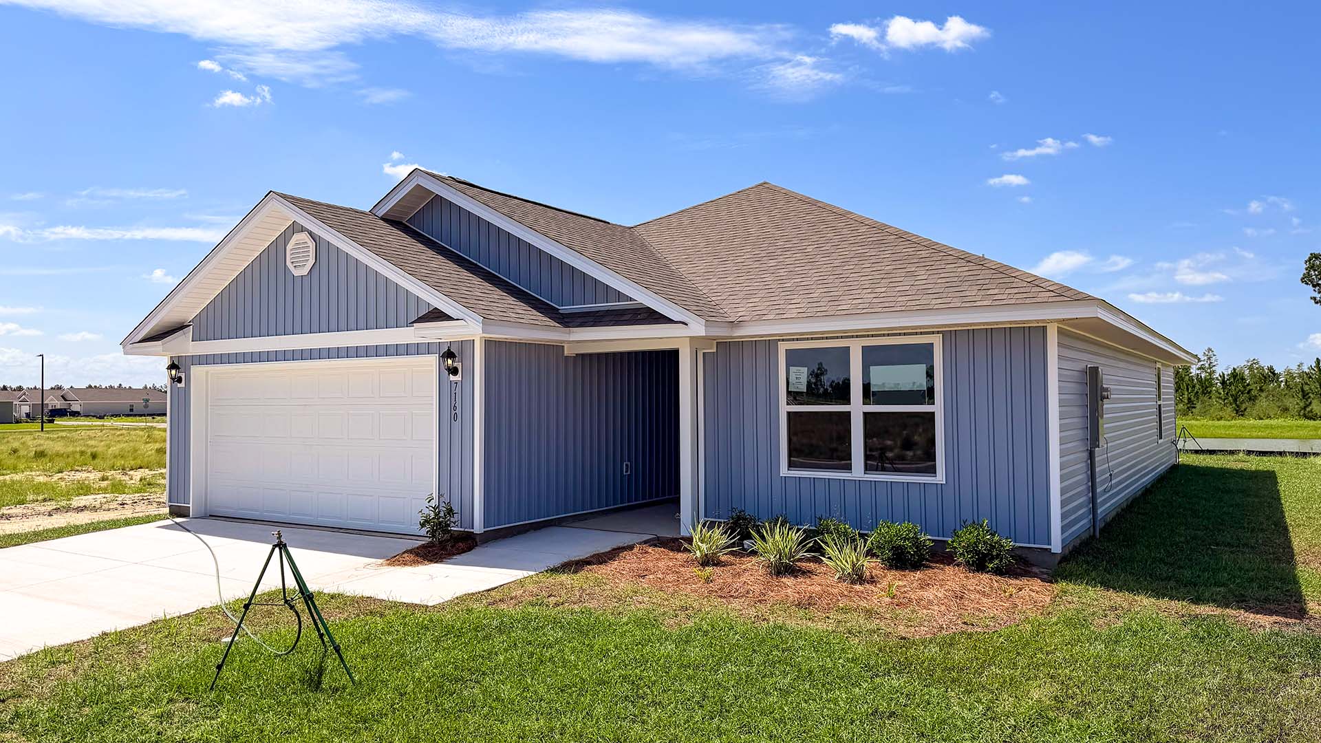 Lismore front of home with vinyl siding and two car garage.