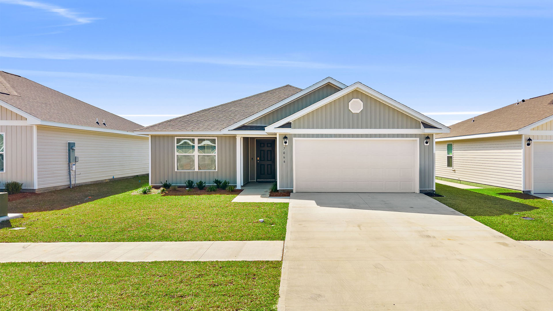 Lismore front of home with vinyl siding and two car garage.