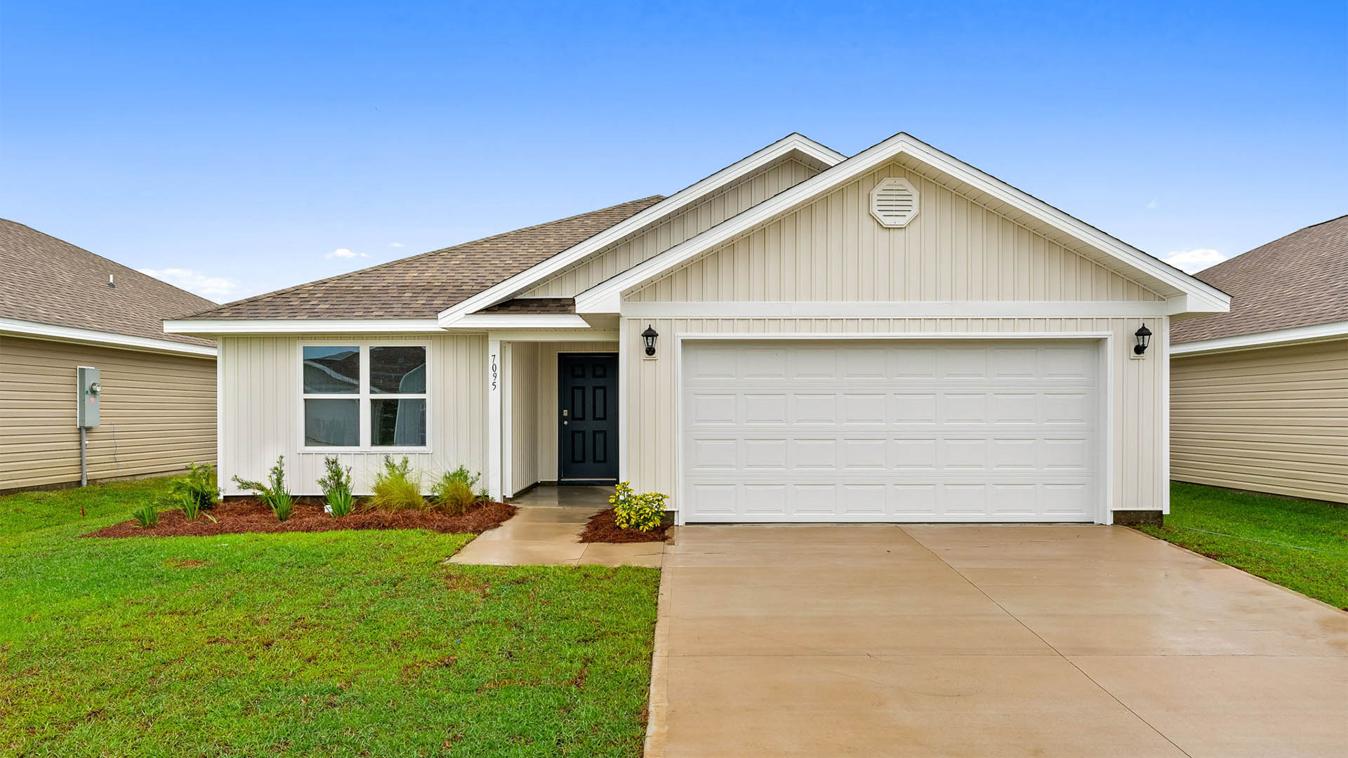 Lismore front of home with vinyl siding and two car garage.