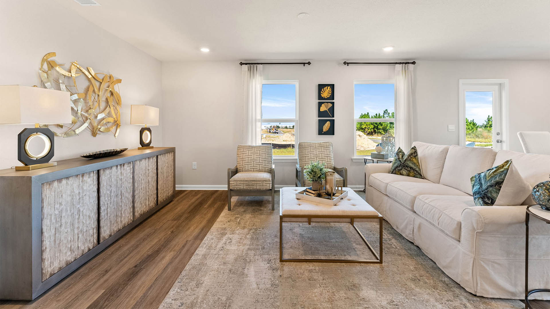 Open living room with windows and dining area next to back door.