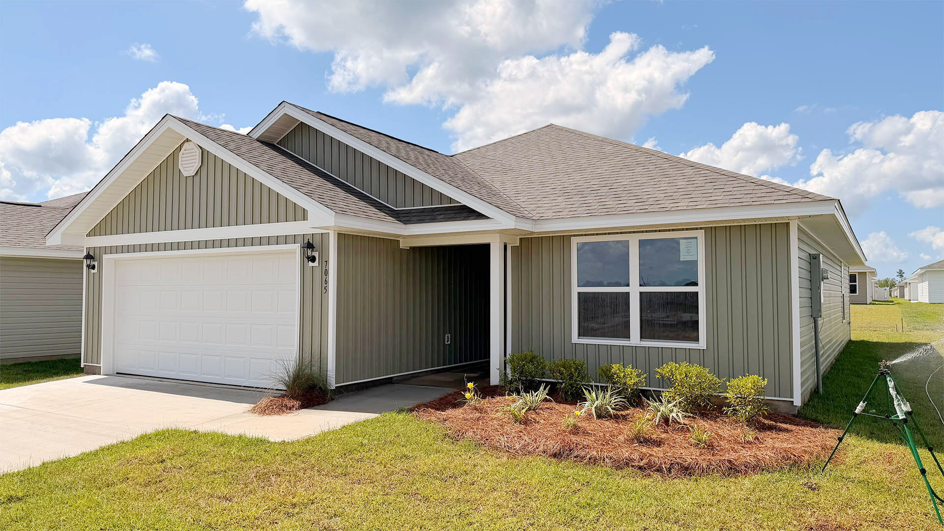 Lismore front of home with vinyl siding and two car garage.