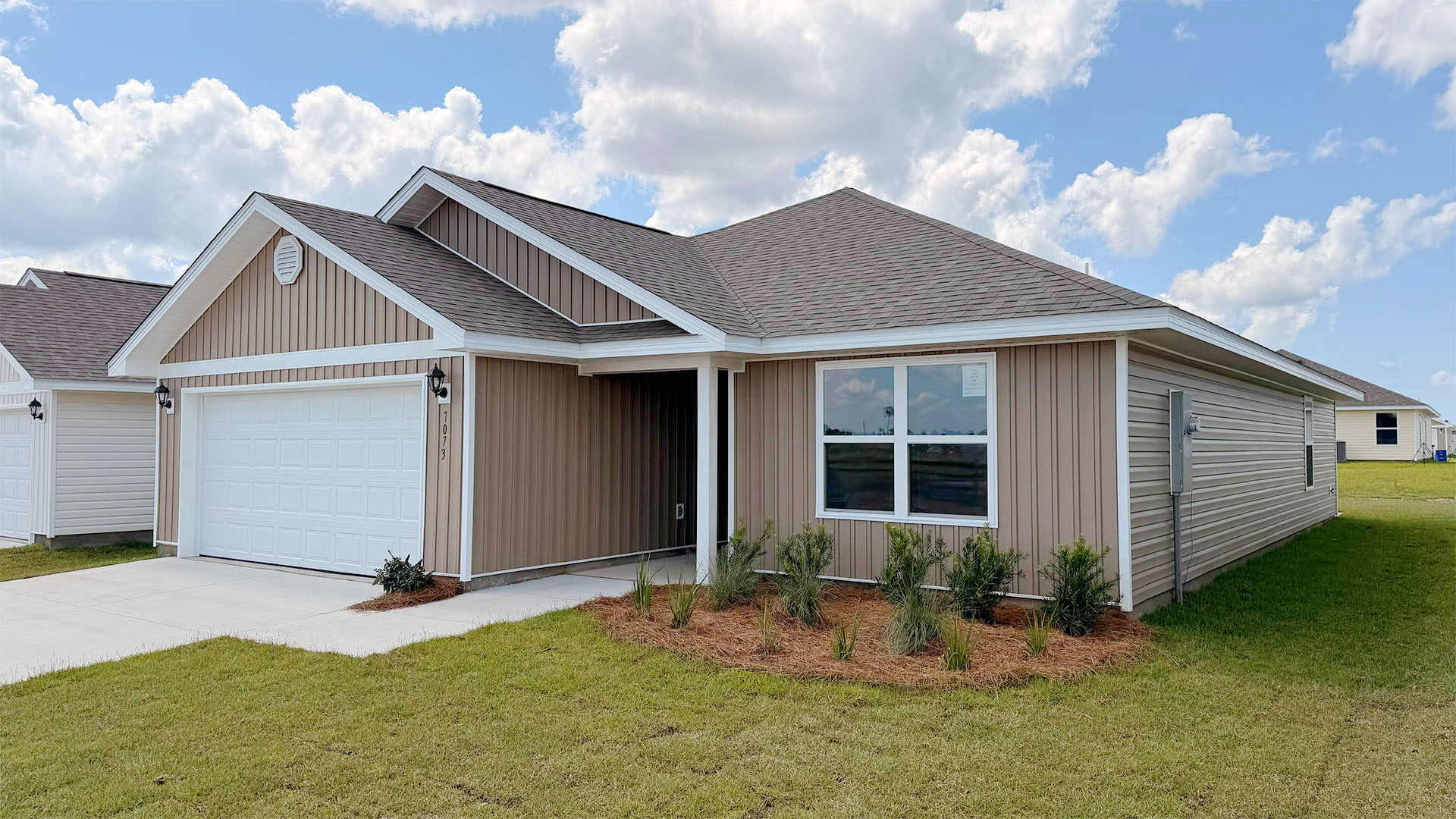 Lismore front of home with vinyl siding and two car garage.