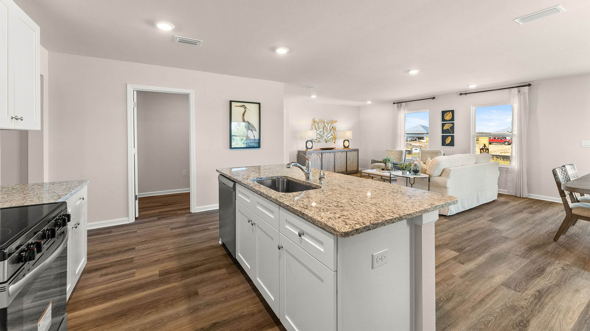 Kitchen with island and white cabinets and stainless-steel appliances and granite countertops.