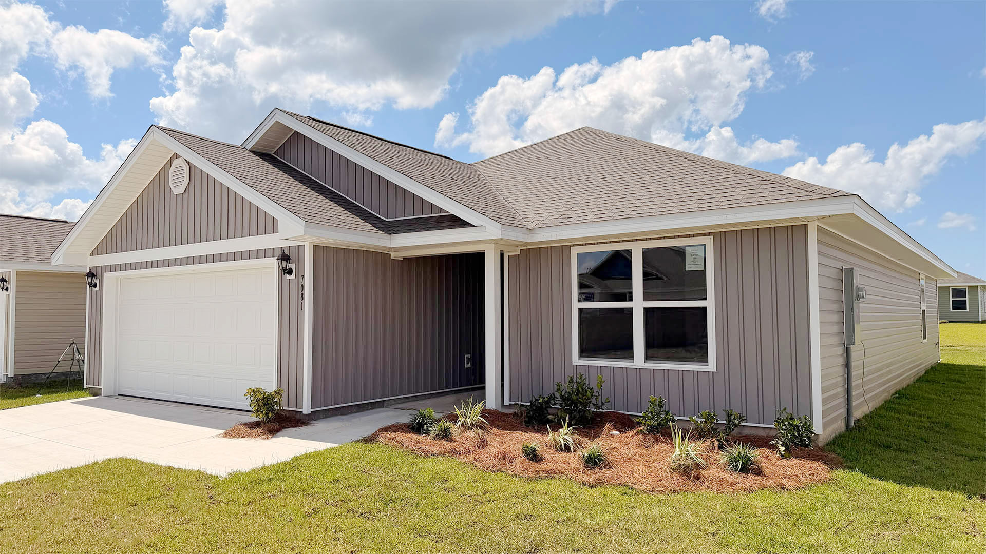 Lismore front of home with vinyl siding and two car garage.