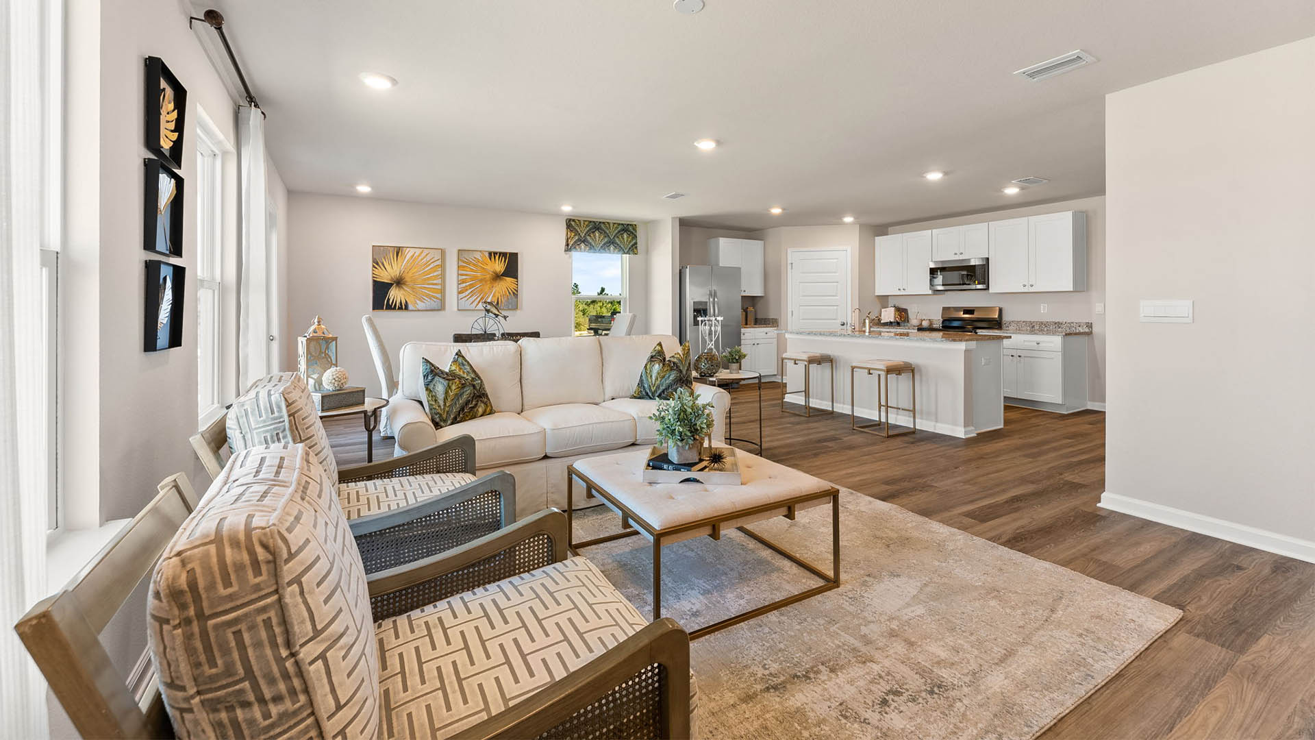 Open living room with windows and dining area next to back door.