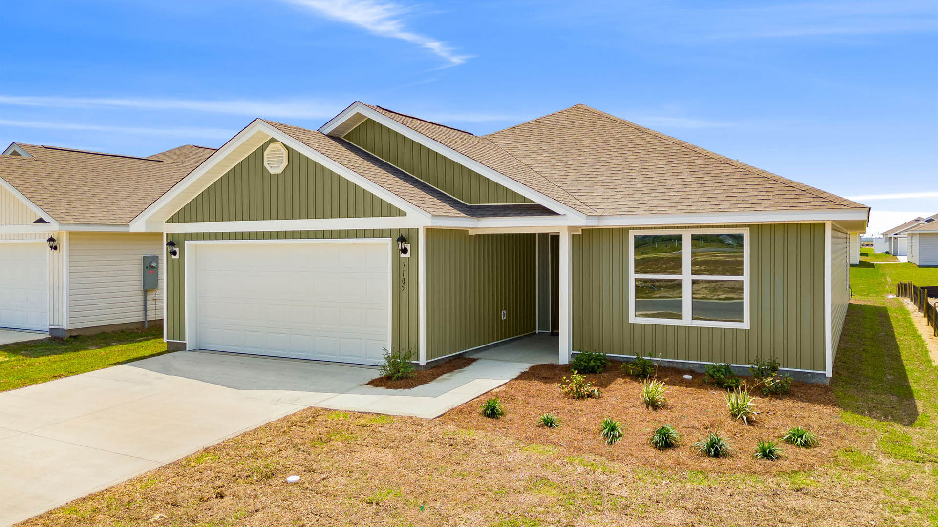 Lismore front of home with vinyl siding and two car garage.