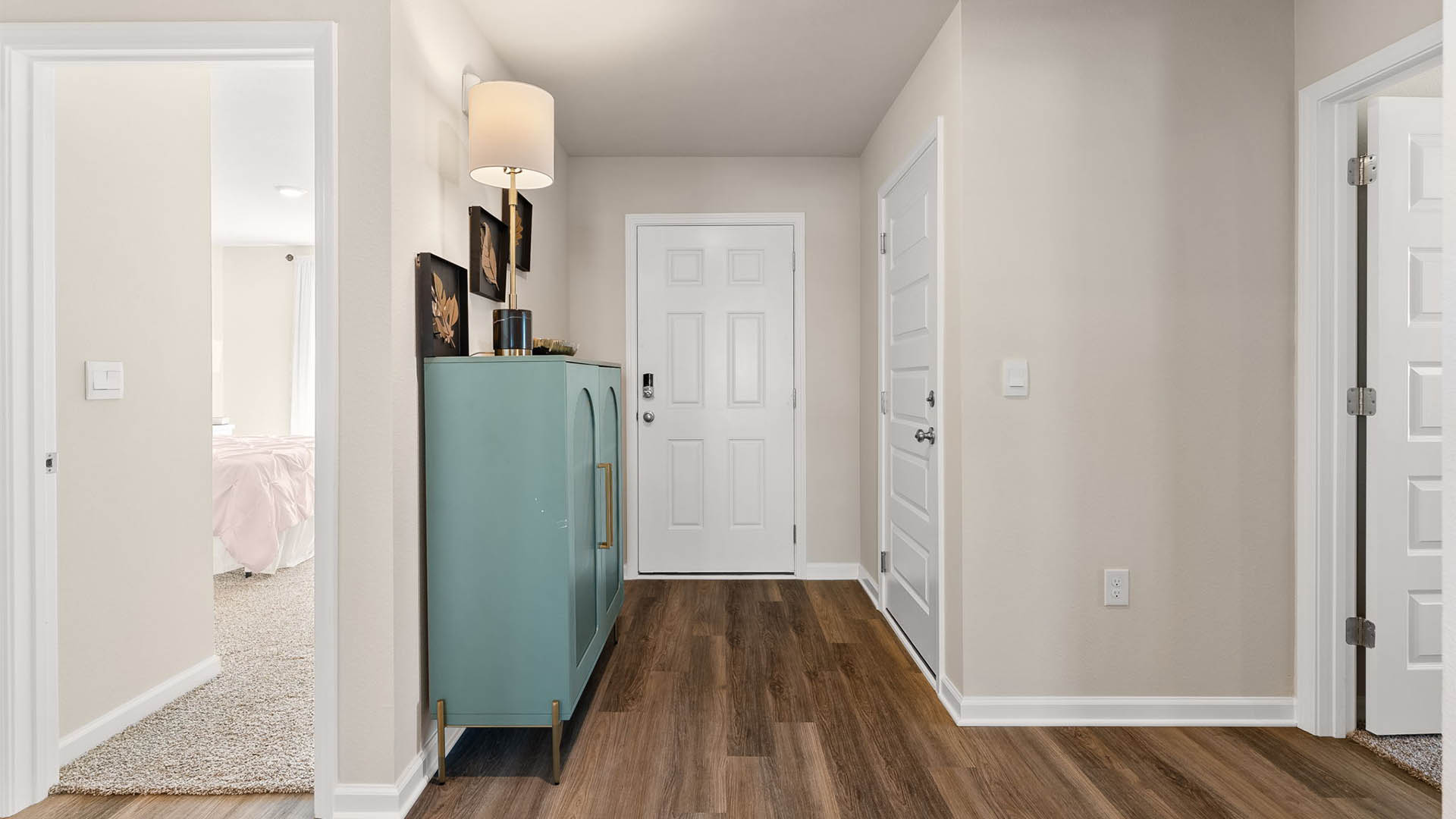 Front hallway next to front door and bedrooms and bathroom and garage.