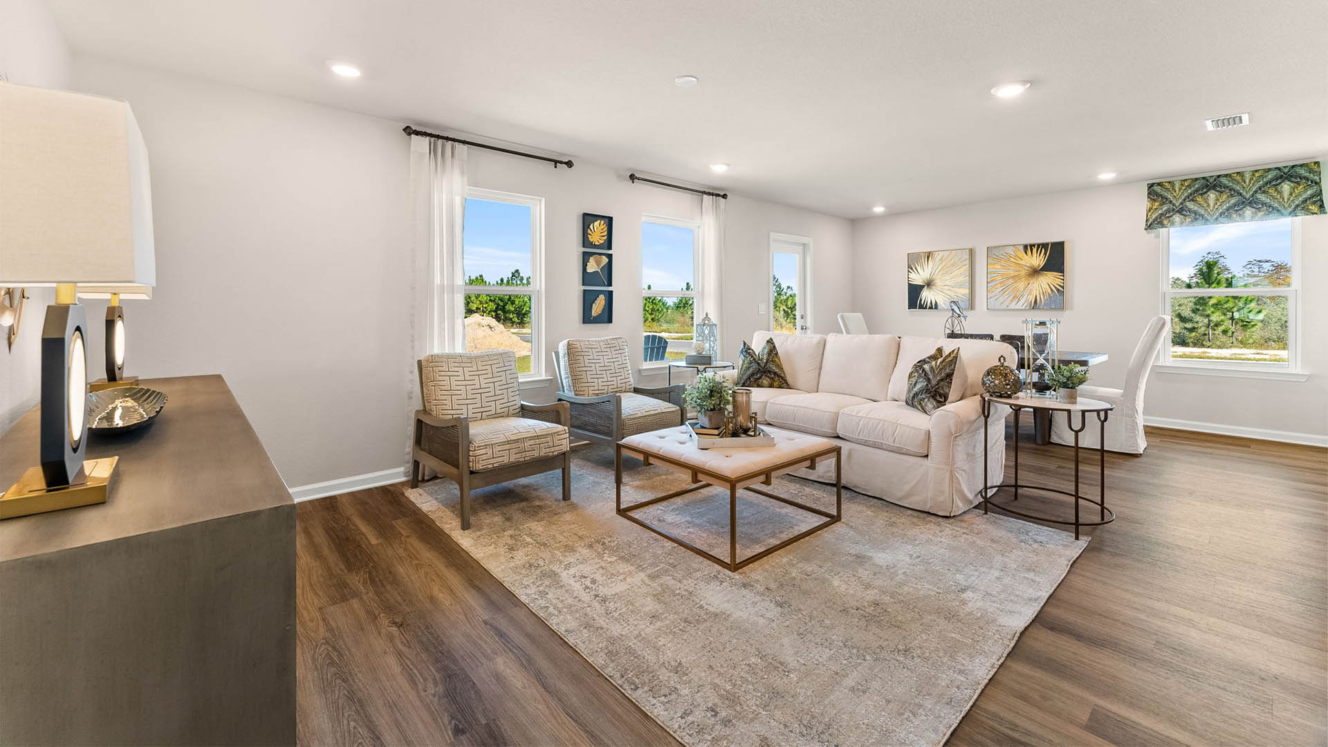 Open living room with windows and dining area next to back door.