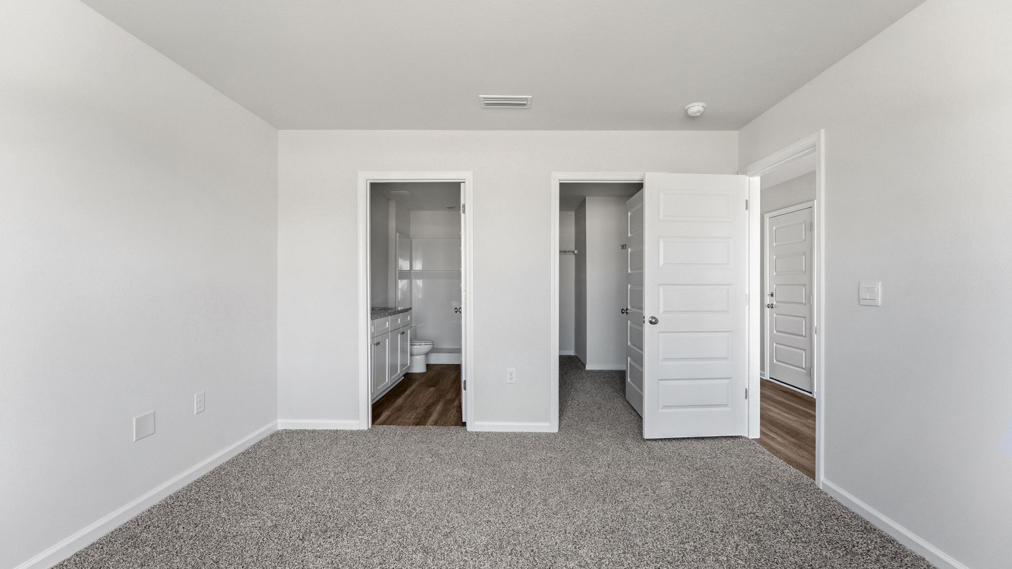 Bedroom with carpet floors and bathroom entrance and closet.