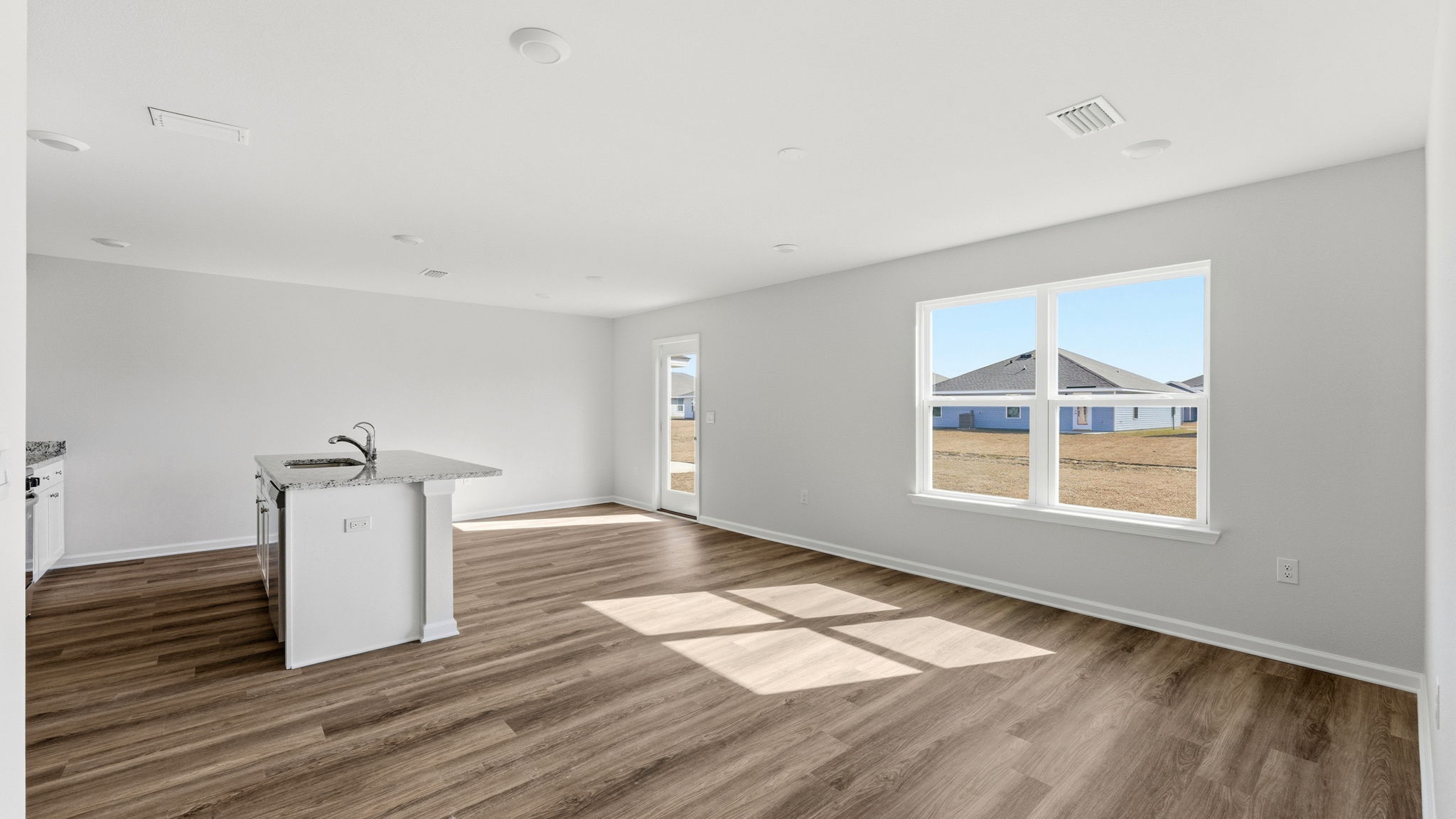 Living room with EVP flooring and dining area and kitchen.