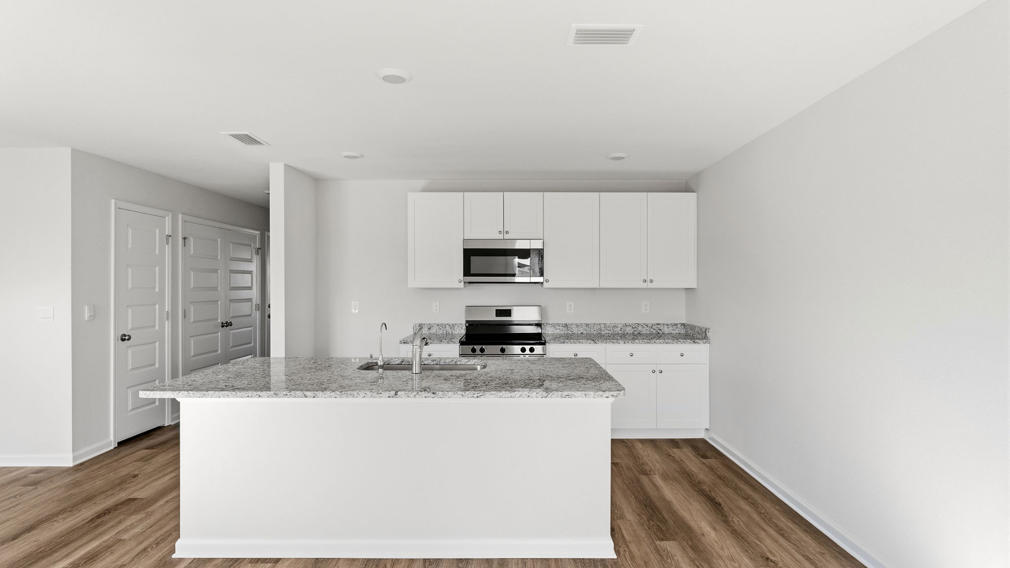 Kitchen and with island and granite countertops and stainless-steel appliances.