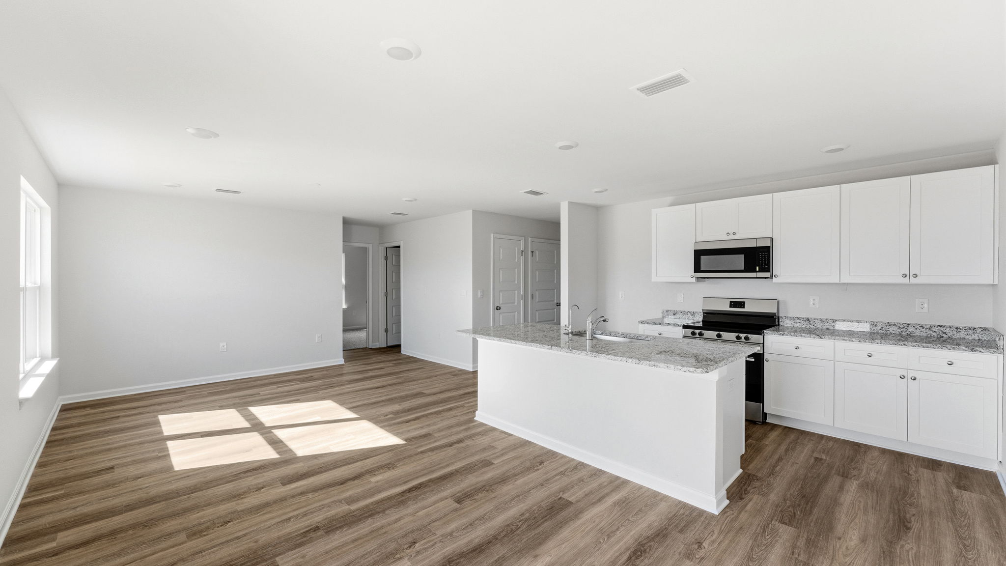 Kitchen and with island and granite countertops and stainless-steel appliances.