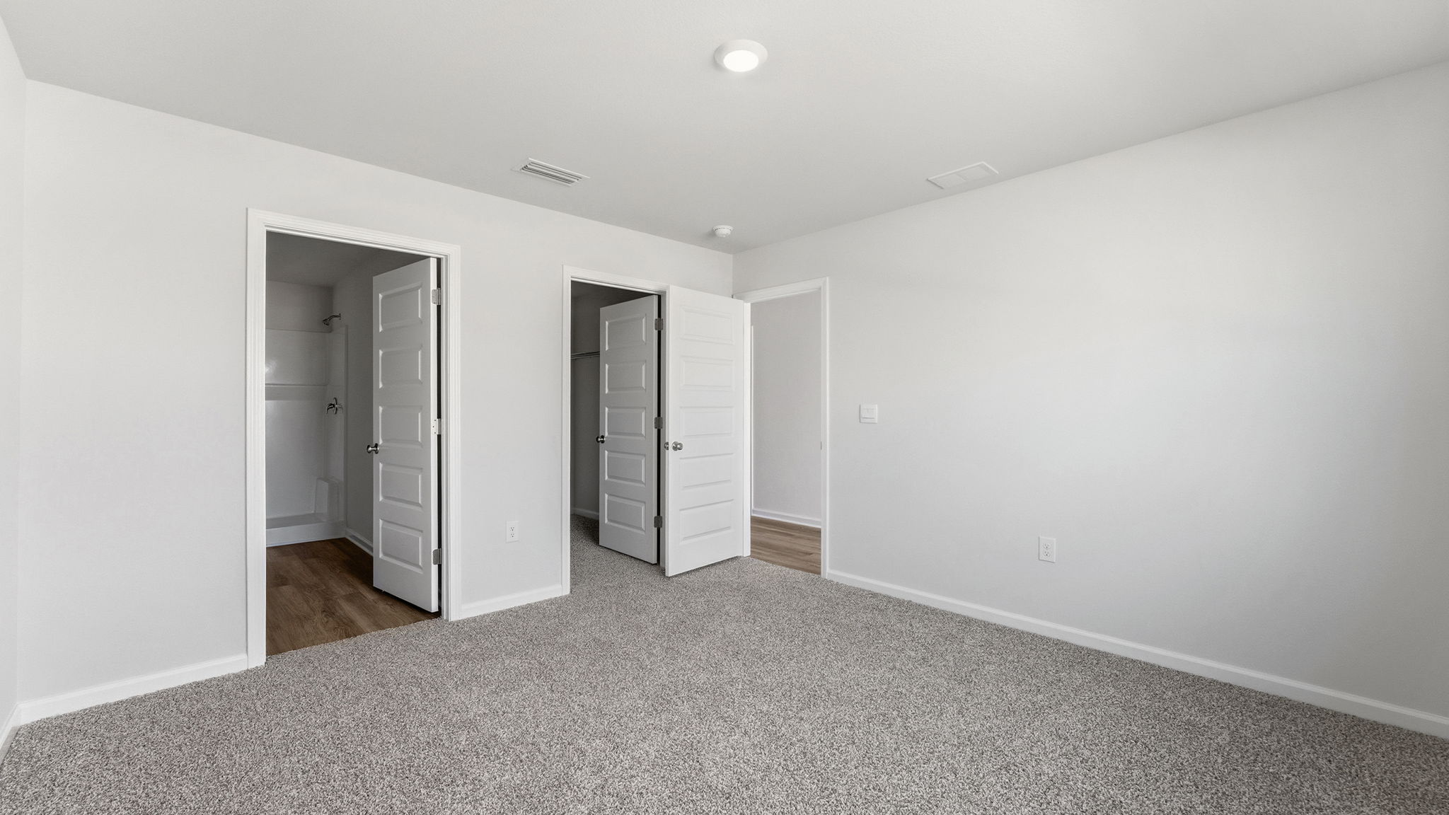 Bedroom with carpet floors and bathroom entrance and closet.