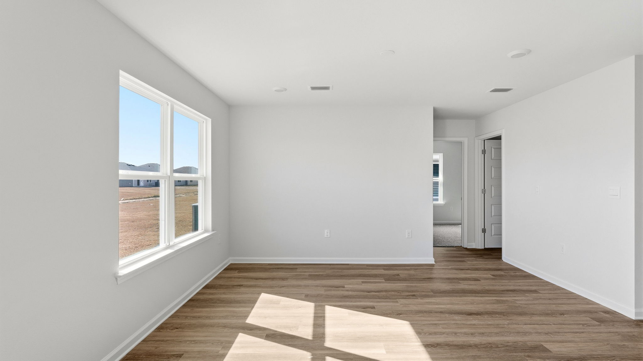 Living room with EVP flooring next to bedrooms.