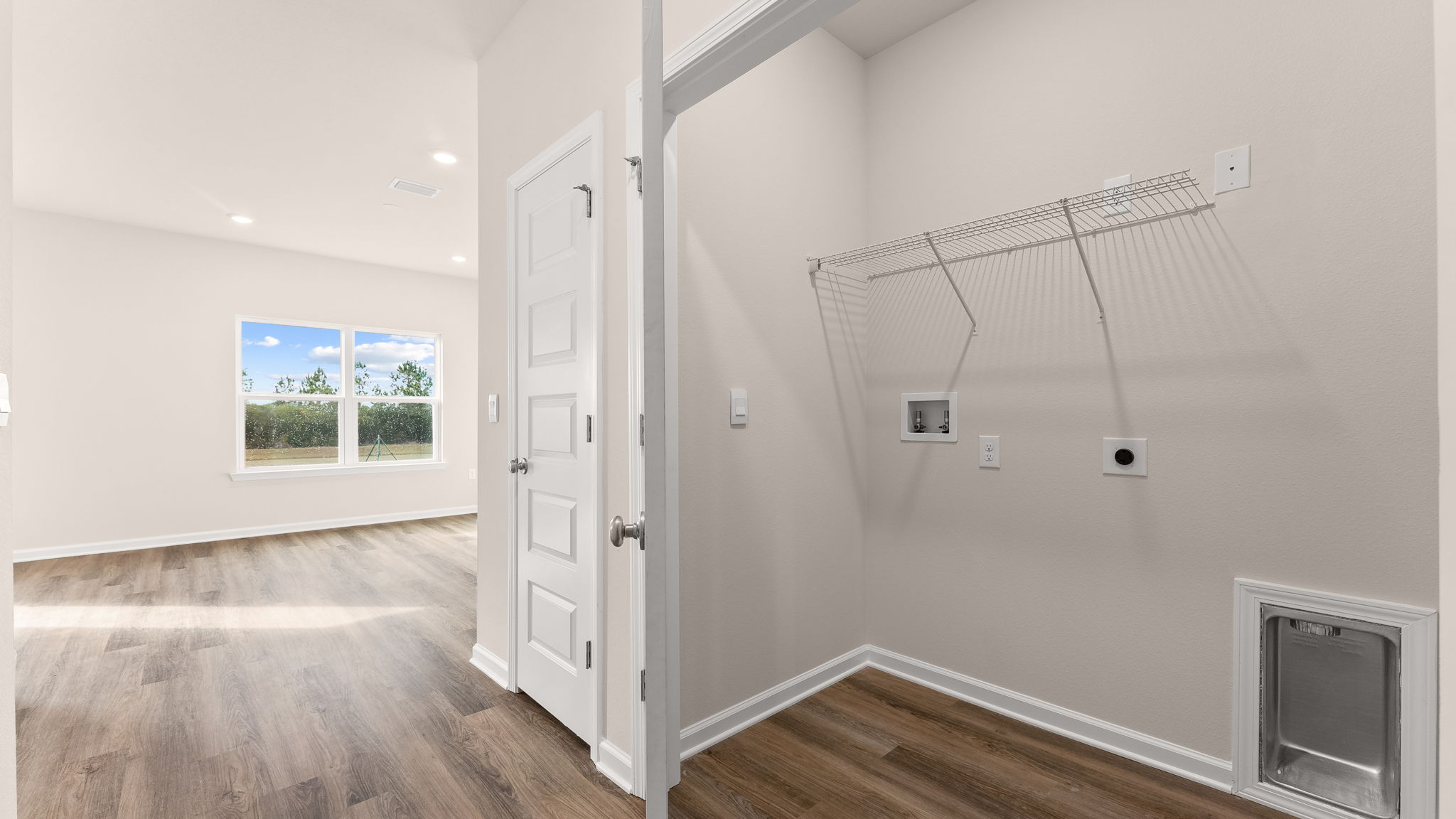 Laundry room in hallway with ventilated shelving.