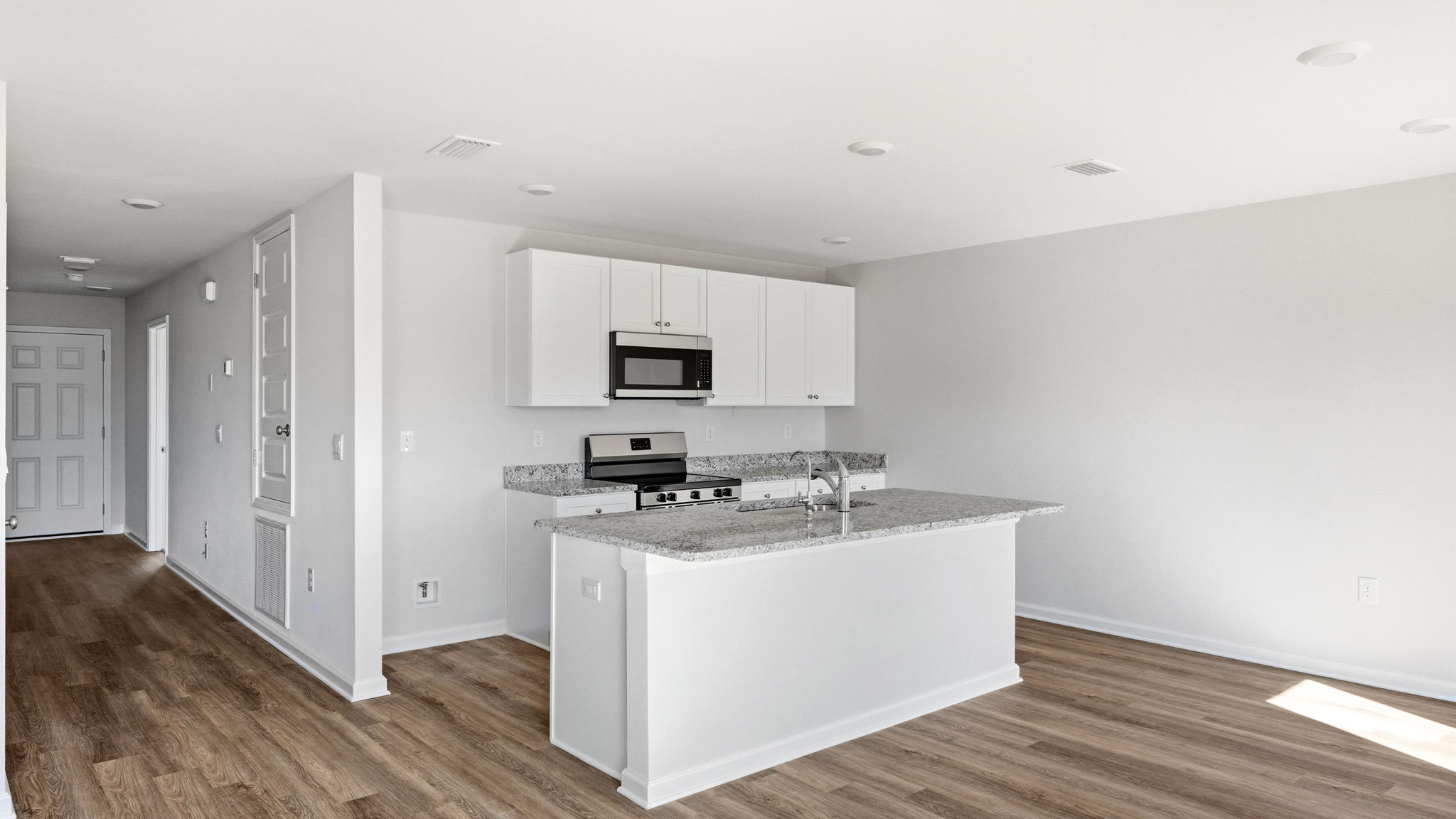 Kitchen and with island and granite countertops and stainless-steel appliances.