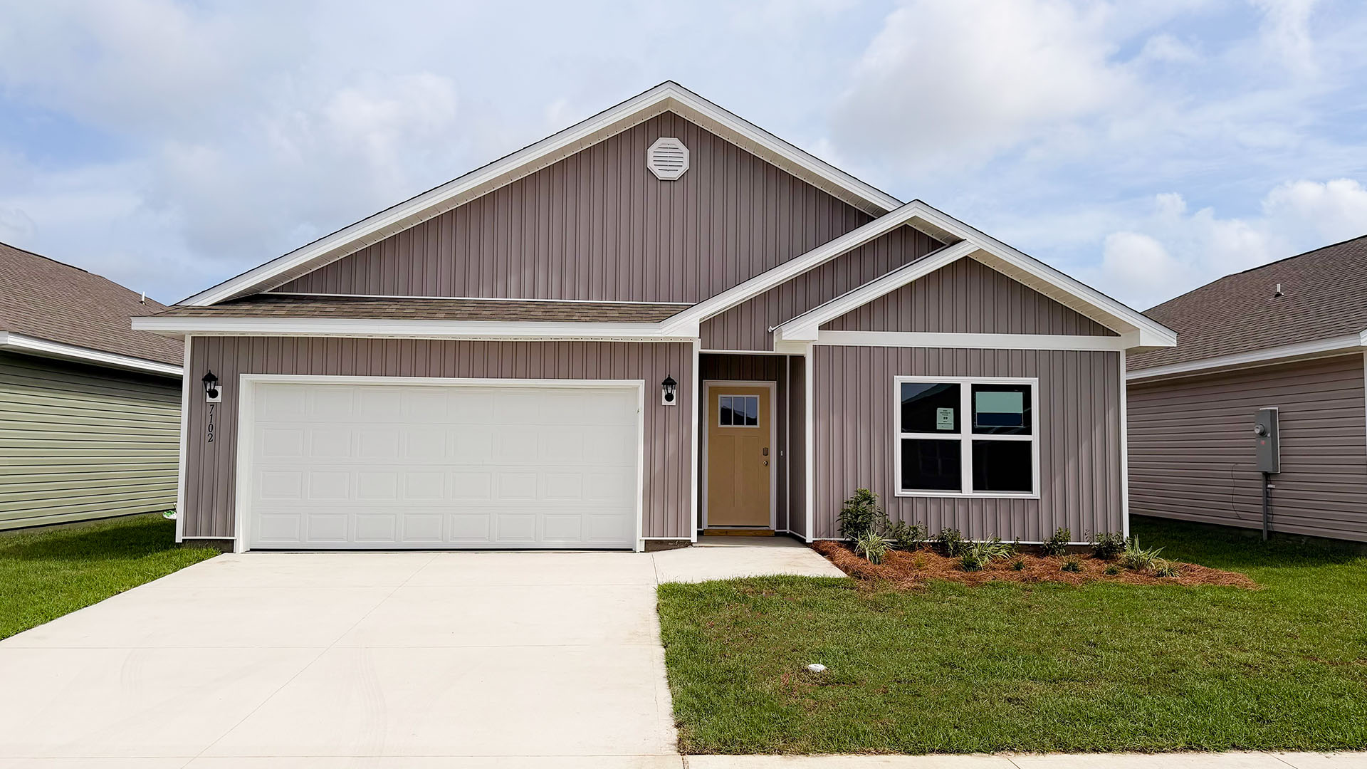Beau plan at Liberty front of home with vinyl siding and two car garage.