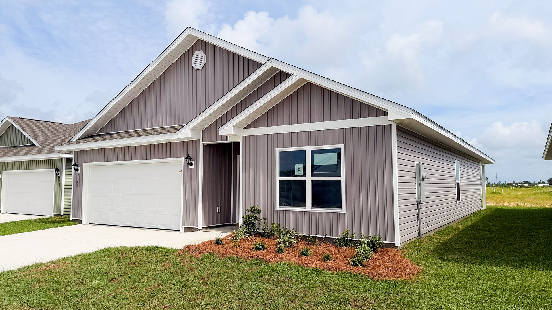 Beau plan at Liberty front of home with vinyl siding and two car garage.