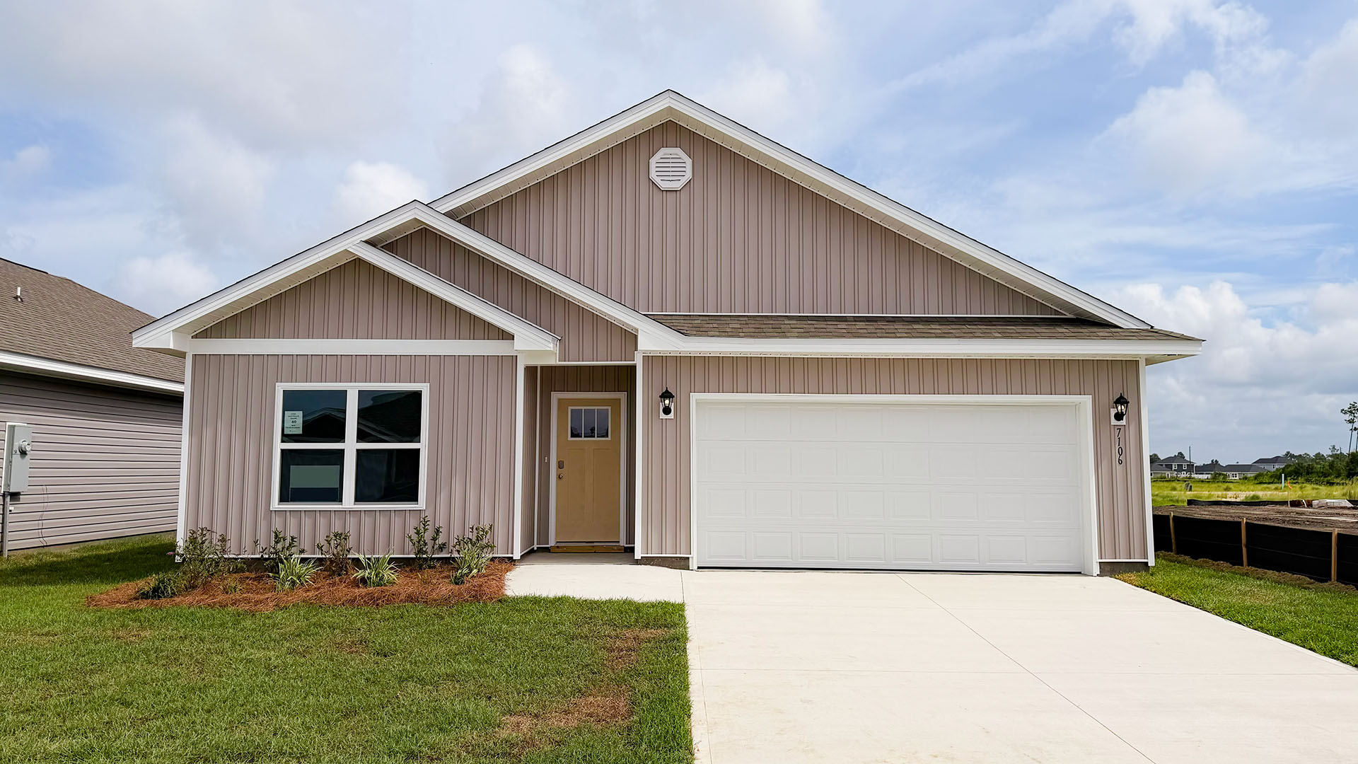 Beau plan at Liberty front of home with vinyl siding and two car garage.