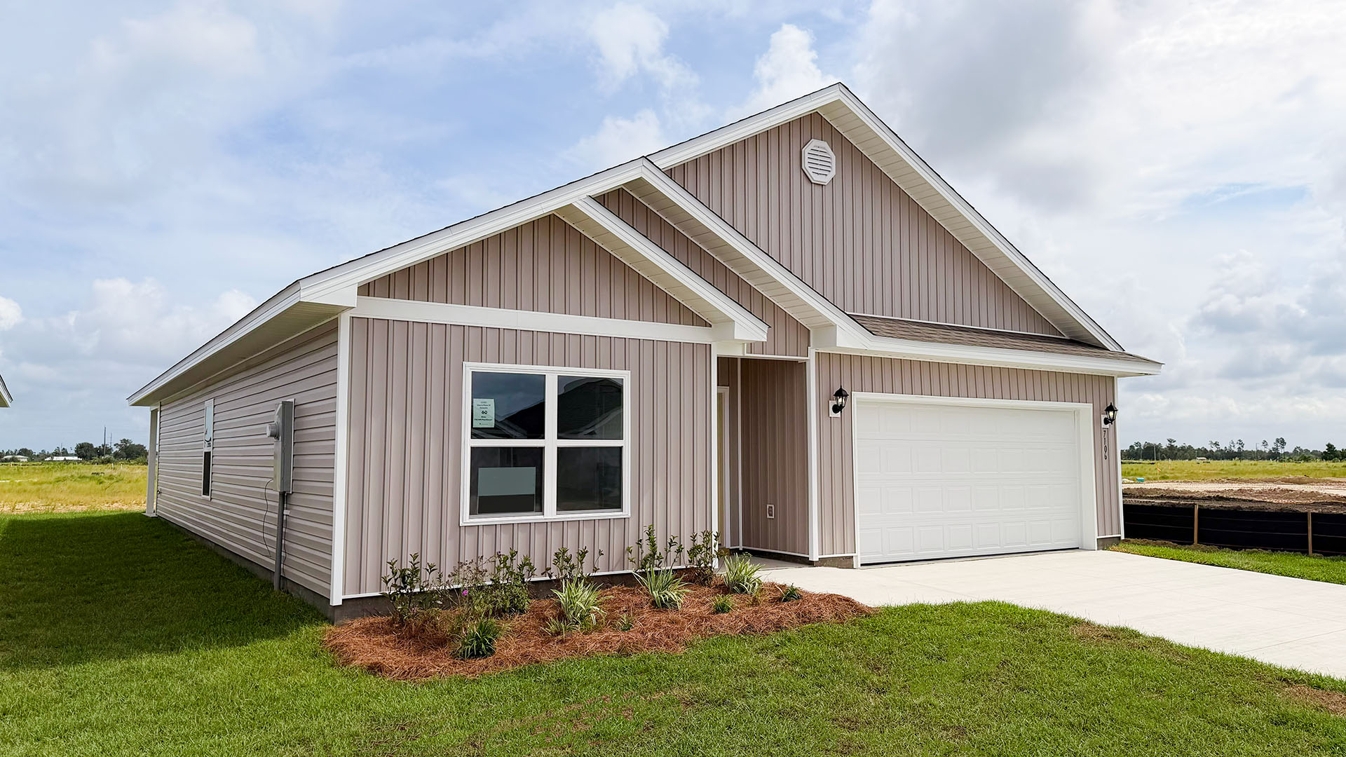 Beau plan at Liberty front of home with vinyl siding and two car garage.