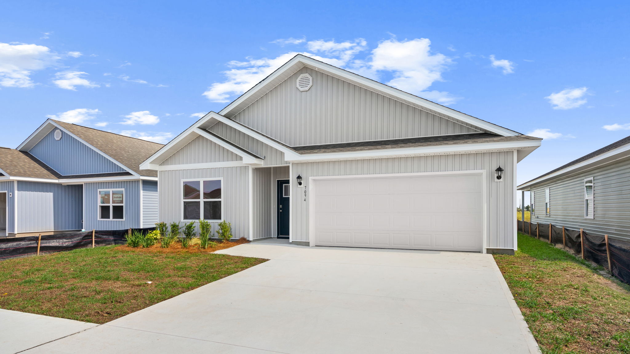 Beau plan at Liberty front of home with vinyl siding and two car garage.
