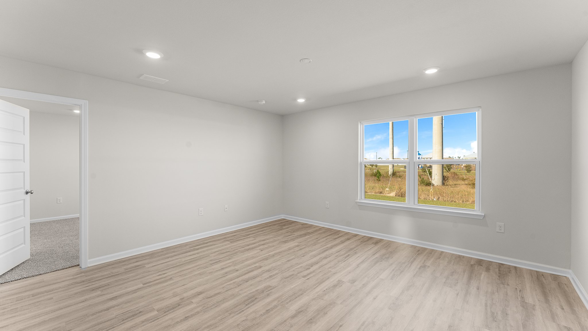 Living room with EVP flooring and two windows.