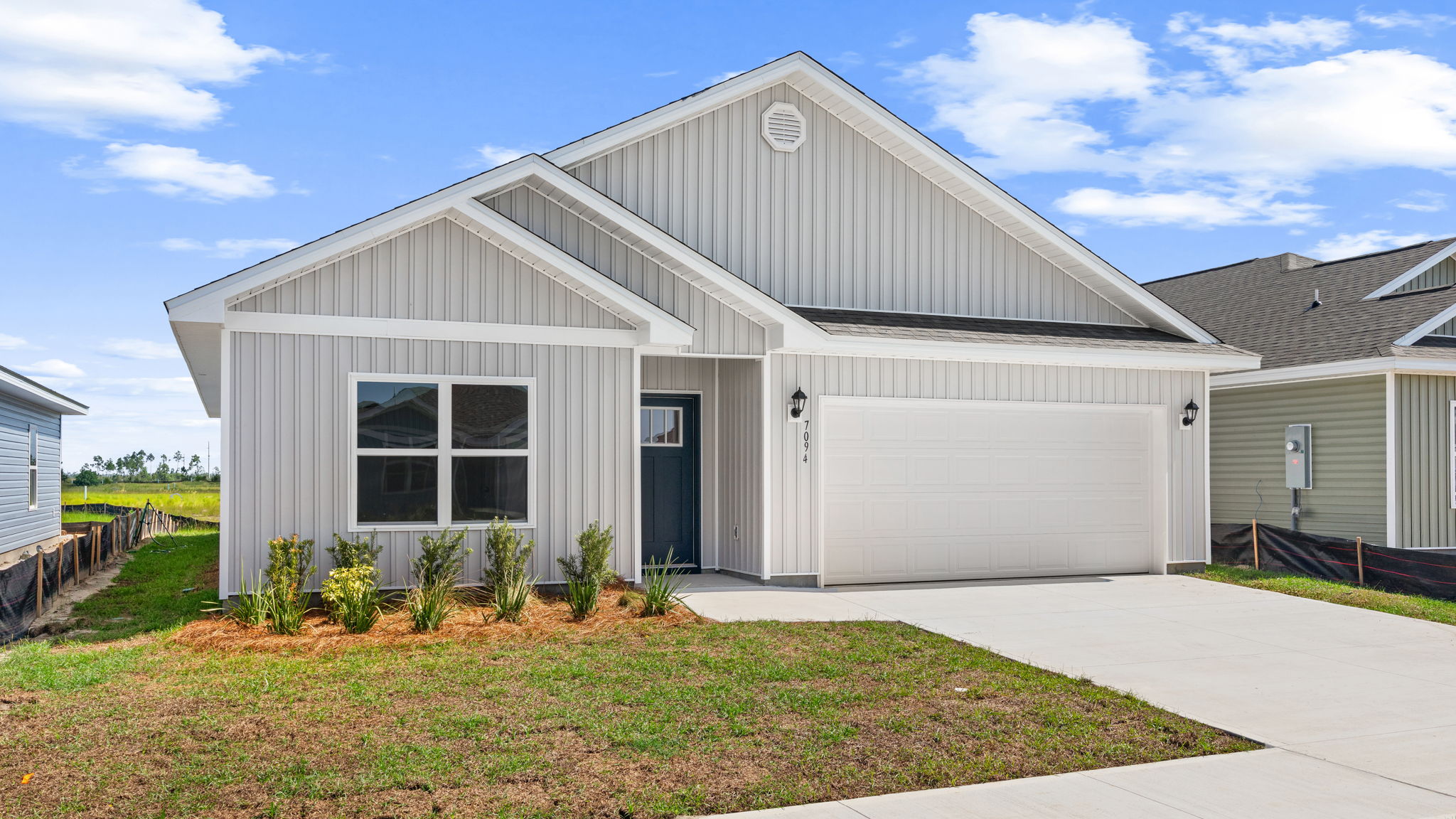 Beau plan at Liberty front of home with vinyl siding and two car garage.