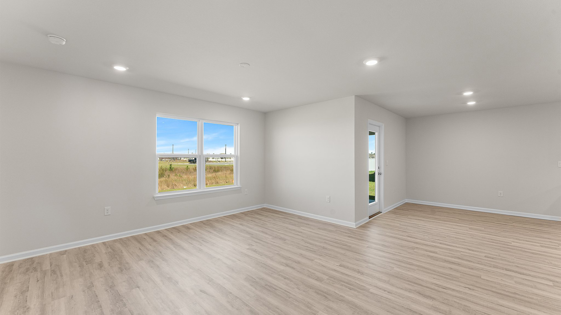 Living room and dining room with back door and two windows.