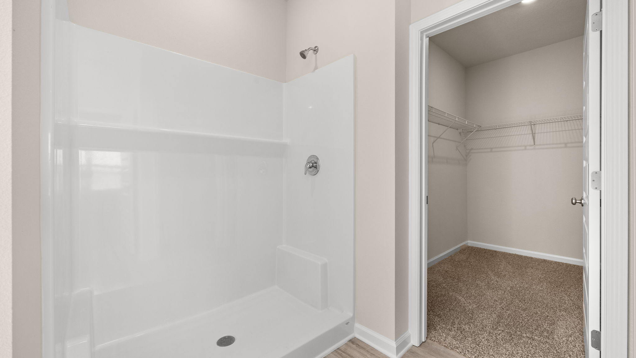 Primary bathroom shower and walk-in closet.