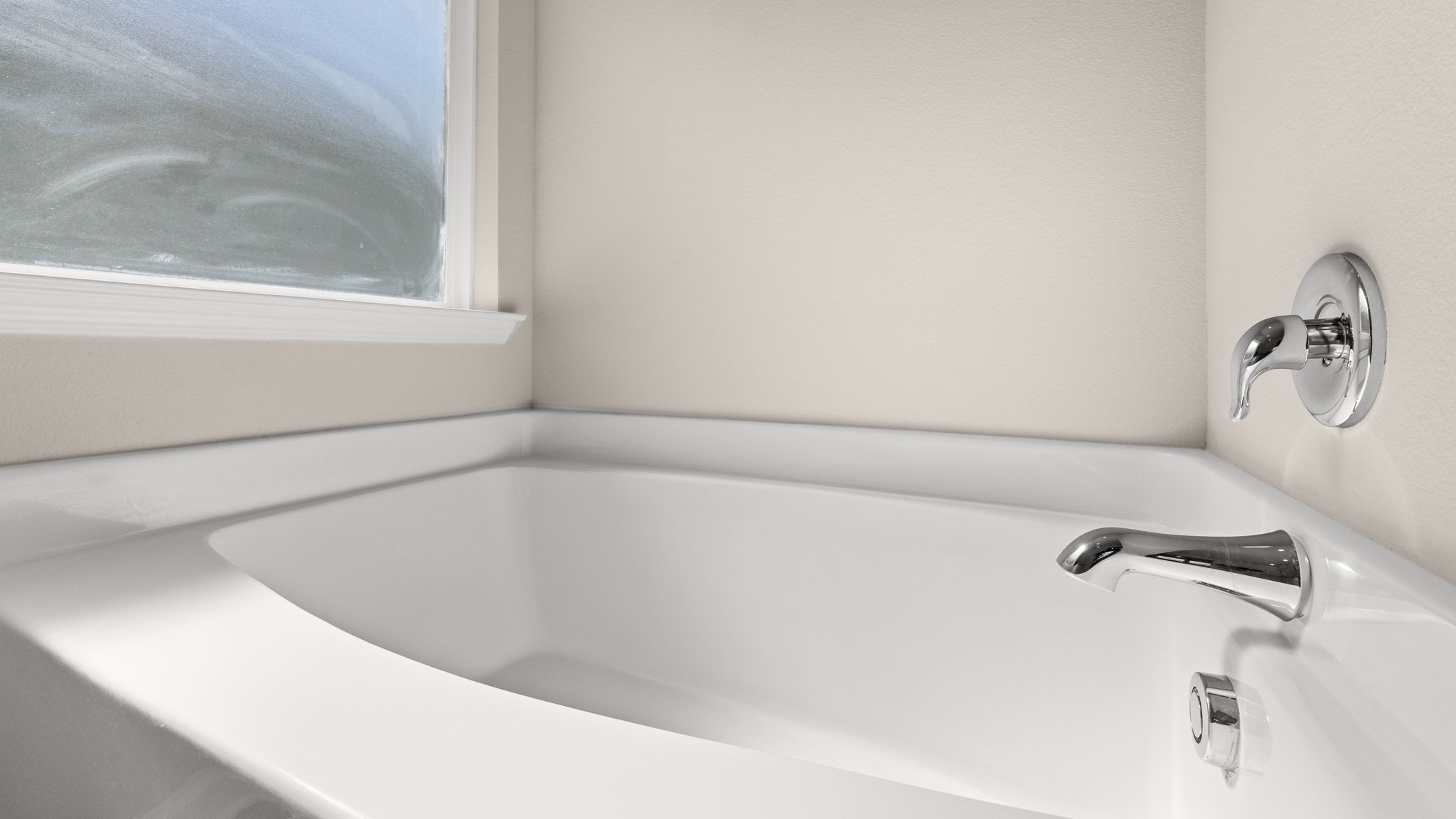 Primary bathroom tub and window.